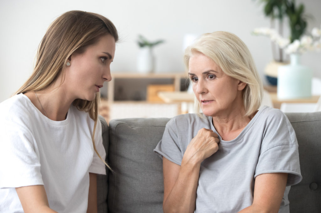 Young woman speaks to older woman as if to comfor her